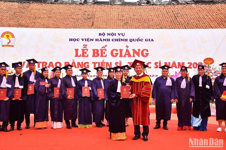 Giám đốc Học viện Hành chính Quốc gia Nguyễn Bá Chiến trao bằng cho các tân Thạc sĩ. (Ảnh: NHẬT QUANG)