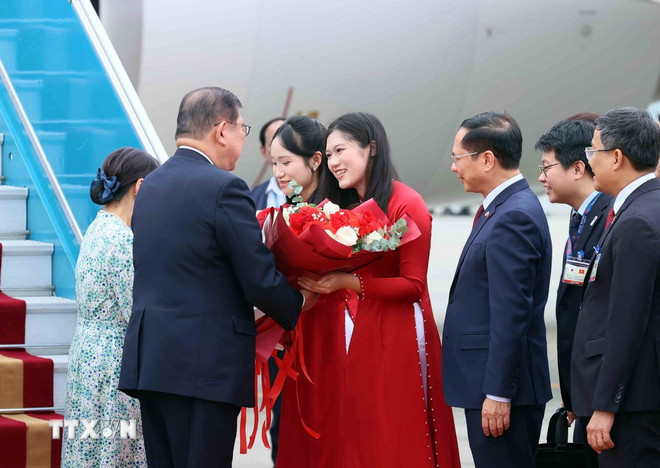 Thiếu nữ Hà Nội tặng hoa, chào mừng Thủ tướng Nhật Bản Ishiba Shigeru và Phu nhân thăm chính thức Việt Nam. (Ảnh: TTXVN)