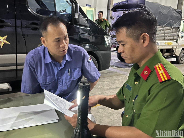 Điều tra viên lấy lời khai một nhân viên đăng kiểm.