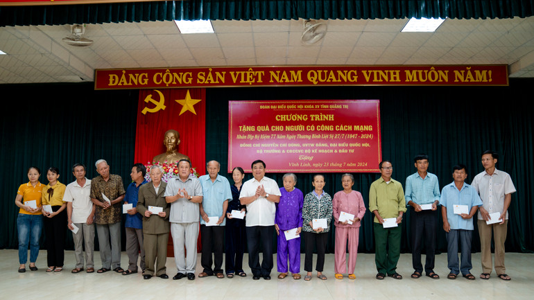 Bộ trưởng Nguyễn Chí Dũng trao quà tặng tặng các gia đình chính sách, thương binh trên địa bàn huyện Vĩnh Linh, tỉnh Quảng Trị. (Ảnh: MINH SƠN)