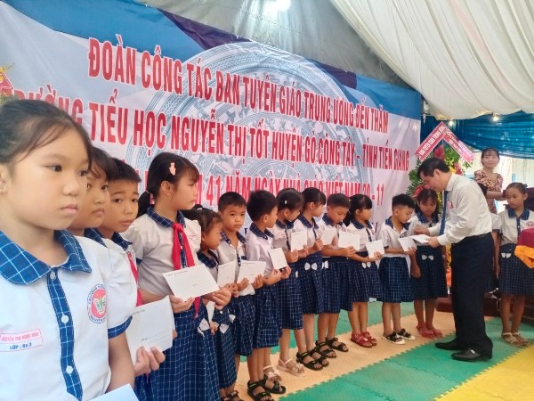 Đồng chí Phan Xuân Thủy trao quà cho các em học sinh khó khăn, học giỏi.