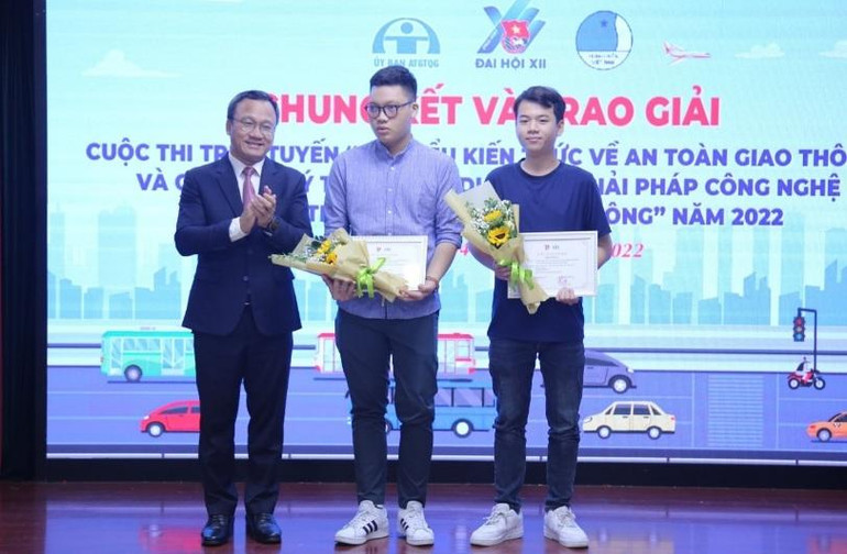 Phó Chủ tịch Thường trực Ủy ban An toàn giao thông quốc gia Khuất Việt Hùng (bên trái) trao giải nhất Cuộc thi “Ý tưởng ứng dụng các giải pháp công nghệ bảo đảm trật tự an toàn giao thông” năm 2022 tặng nhóm tác giả Nguyễn Duy Khang, Trần Viết Lân.