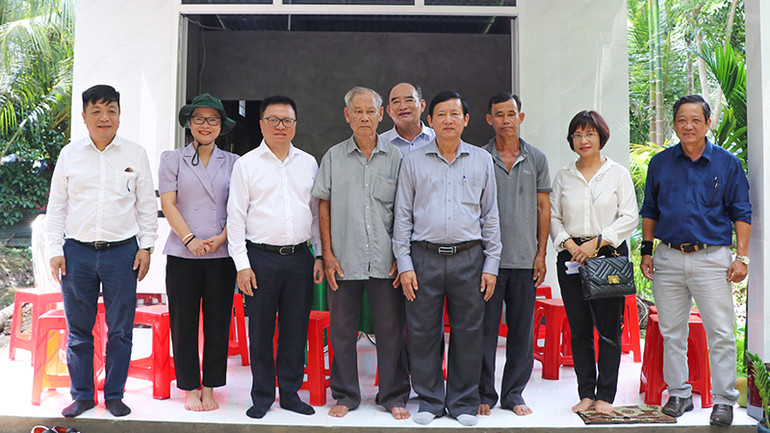 Tổng Biên tập Báo Nhân Dân Lê Quốc Minh cùng đoàn công tác thăm nhà và chụp hình lưu niệm.