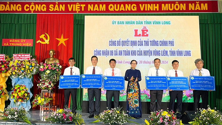 Phó Chủ tịch Ủy ban nhân dân tỉnh Vĩnh Long Nguyễn Thị Quyên Thanh trao bảng hỗ trợ thẻ bảo hiểm y tế cho người dân xã an toàn khu.