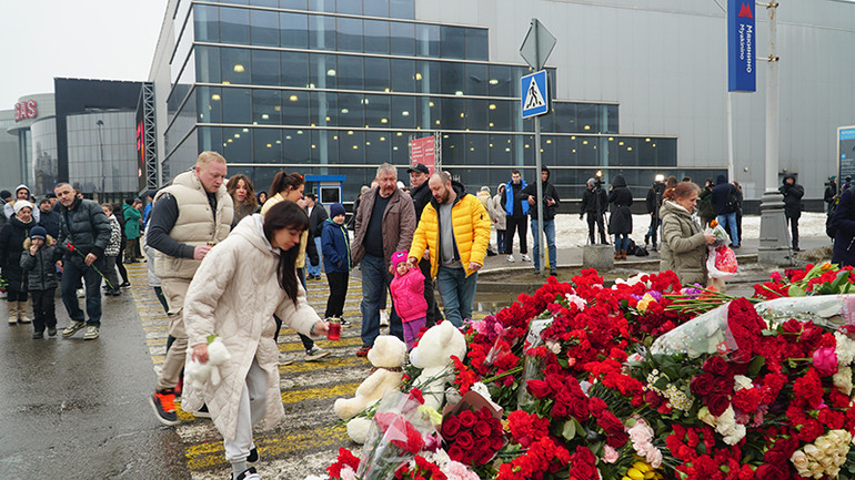 Nhiều người dân đưa trẻ nhỏ đến đặt hoa, thú bông. (Ảnh: THÙY VÂN)