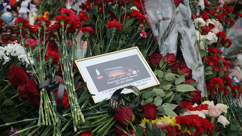 Khung ảnh với dòng chữ “tiếc thương các nạn nhân ngày 22/3” được đặt tại khu tưởng niệm gần hiện trường vụ tấn công khủng bố. (Ảnh: THÙY VÂN)