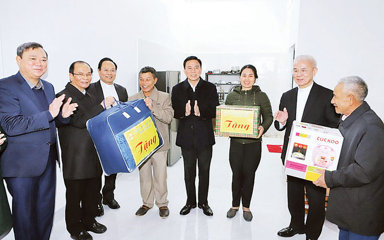 Đại diện tổ chức tôn giáo cùng lãnh đạo tỉnh Thanh Hóa trao tặng đồ dùng thiết yếu cho các hộ sinh sống trên sông lên bờ cư trú ổn định. (Ảnh MAI LUẬN)