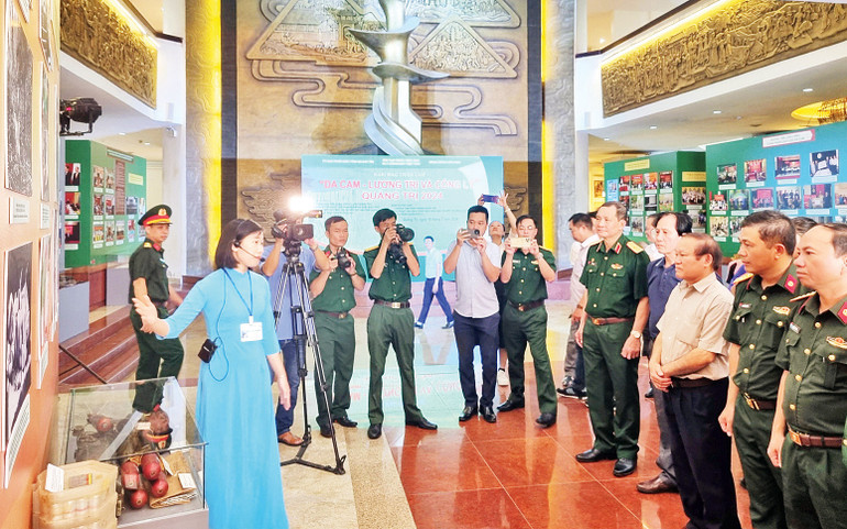 Du khách nghe thuyết minh tại triển lãm. (Ảnh TÚ LINH)