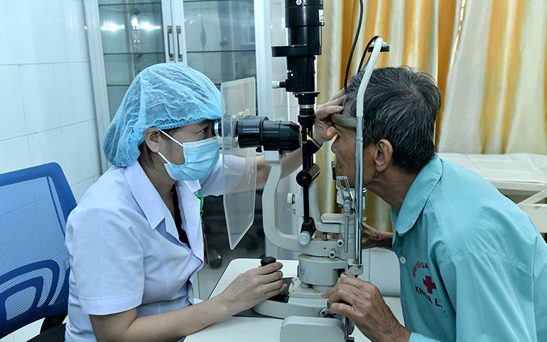 Bác sĩ khám mắt cho bệnh nhân cao tuổi tại Bệnh viện đa khoa huyện Vĩnh Linh (Quảng Trị). (Ảnh THANH TRÚC)