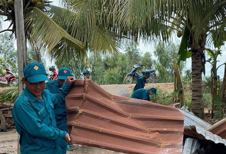 Dân quân giúp dân dựng lại nhà ở do lốc xoáy gây ra vào chiều tối ngày 13/9.