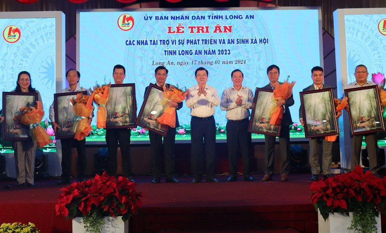 Nguyên Chủ tịch nước Trương Tấn Sang và Chủ tịch Ủy ban nhân dân tỉnh Long An Nguyễn Văn Út tặng hoa và quà tri ân nhà tài trợ.