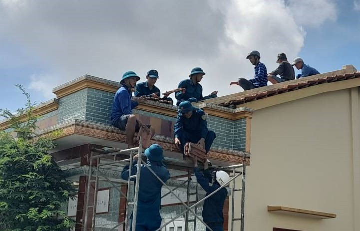 Lực lượng dân quân địa phương hỗ trợ bà con lợp lại mái nhà do vòi rồng hút bay.