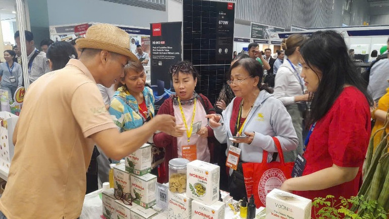 Khách hàng tìm hiểu sản phẩm OCOP tiêu biểu của doanh nghiệp Long An sản xuất từ dược liệu trưng bày tại hội chợ.