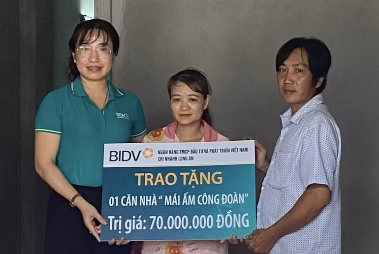 Nhà tài trợ trao tặng tiền hỗ trợ cho người lao động xây nhà.