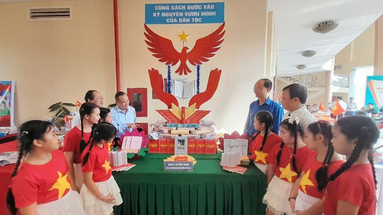 Lãnh đạo tỉnh, huyện và học sinh tham quan không gian giới thiệu sách, triển lãm trưng bày sách tại lễ phát động.