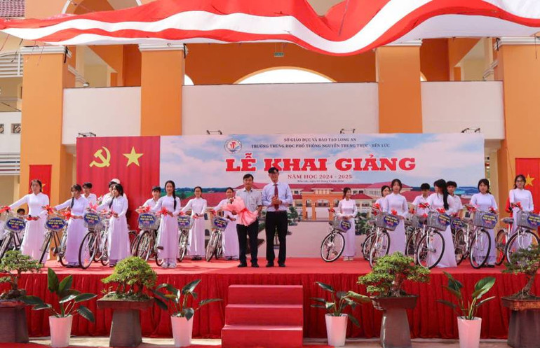 Lãnh đạo Trường trung học phổ thông Nguyễn Trung Trực và nhà tài trợ trao xe đạp cho học sinh có hoàn cảnh khó khăn.