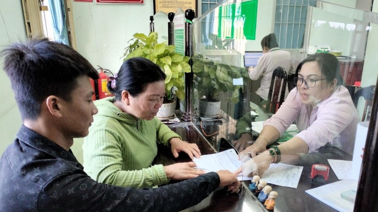 Ngân hàng Chính sách xã hội huyện Đức Huệ, Long An làm thủ tục cho người dân nghèo vay vốn phát triển sản xuất.