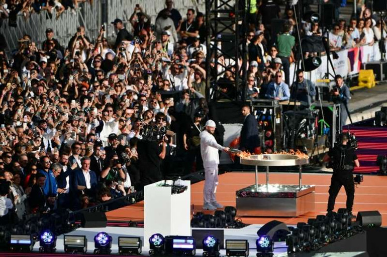 Ngôi sao nhạc rap Jul là người trực tiếp thắp sáng chiếc vạc Olympic từ ngọn đuốc truyền thống. (Ảnh: BFM)