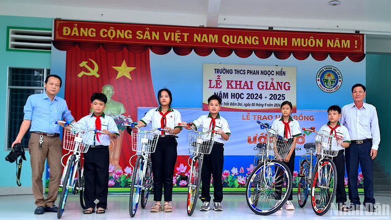 Đại diện Báo Nhân Dân tại Cà Mau (bìa trái) trao hỗ trợ xe đạp tại huyện Đầm Dơi (tỉnh Cà Mau). Đại diện Báo Nhân Dân tại Cà Mau (bìa trái) trao hỗ trợ xe đạp tại huyện Đầm Dơi (tỉnh Cà Mau).