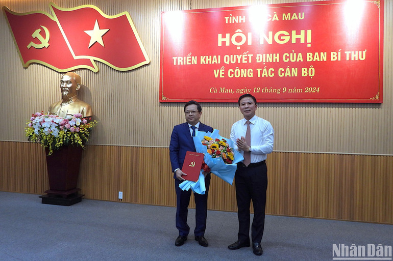 Phó Trưởng Ban Tổ chức Trung ương Đỗ Trọng Hưng (phải) trao quyết định và tặng hoa chúc mừng đồng chí Nguyễn Đức Hiển.