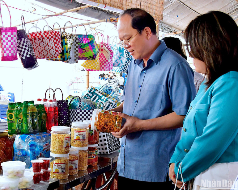 Bí thư Tỉnh ủy Cà Mau Nguyễn Hồ Hải (đeo kính) kiểm tra việc niêm yết giá tại một gian hàng trưng bày các sản phẩm OCOP ở Ngày hội Bánh dân gian vào chiều 29/4.