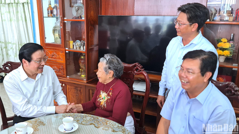 Đồng chí Phan Đình Trạc (bía trái) thăm hỏi sức khỏe Mẹ Việt Nam Anh hùng Nguyễn Kim Mai (thành phố Cà Mau).