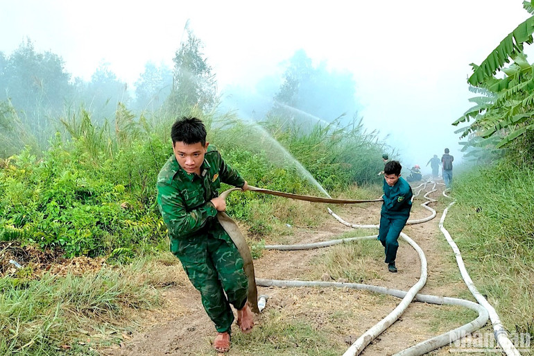 Lực lượng chuyên dụng nỗ lực kéo ống dẫn nước chữa cháy.