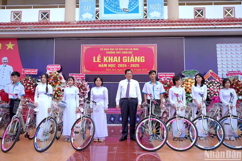 Phó Chủ tịch Ủy ban nhân dân tỉnh Cà Mau Lâm Văn Bi (giữa) trao tặng xe đạp cho các học sinh khó khăn Trường THPT Đầm Dơi (huyện Đầm Dơi, tỉnh Cà Mau) vào sáng 5/9.