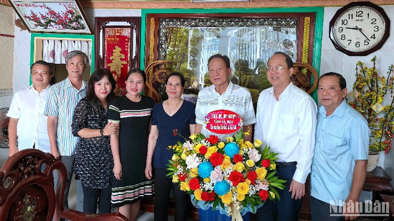 Bí thư Tỉnh ủy Cà Mau Nguyễn Hồ Hải (đeo kính) cùng đoàn công tác chụp ảnh lưu niệm tại gia đình Bác sĩ Nhan Văn Đấu, nguyên Giám đốc Bệnh viện đa khoa Cà Mau.