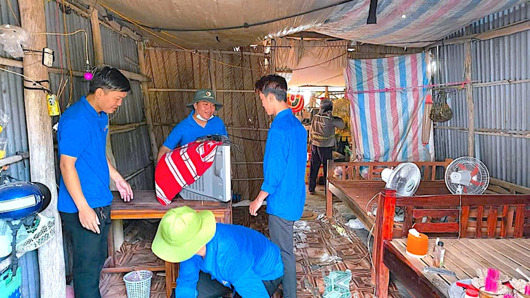 Các bạn đoàn viên Cà Mau thu dọn vật dụng trong nhà giúp hộ dân.
