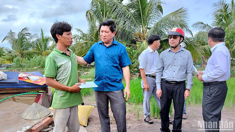 Phó Chủ tịch Ủy ban nhân dân tỉnh Cà Mau Lê Văn Sử (áo xanh) thăm hỏi, trao hỗ trợ cho hộ dân huyện U Minh có nhà bị thiệt hại do thiên tai.