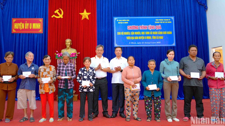 Đại diện đoàn công tác Văn phòng Thành ủy Thành phố Hồ Chí Minh trao quà cho hộ nghèo, cận nghèo trên địa bàn huyện U Minh vào sáng 21/3.