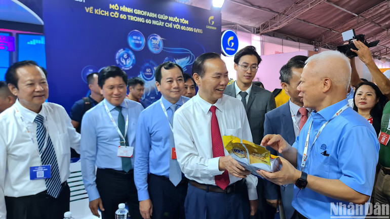 Thứ trưởng Nông nghiệp và Phát triển nông thôn Phùng Đức Tiến (cà vạt đỏ) tham quan không gian trưng bày sản phẩm ngành tôm tại hội chợ triển lãm.