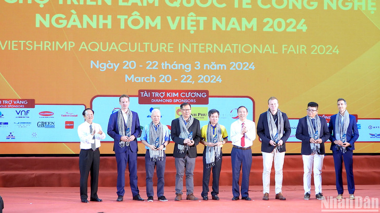 Thứ trưởng Nông nghiệp và Phát triển nông thôn Phùng Đức Tiến (cà vạt đỏ) tham quan không gian trưng bày sản phẩm ngành tôm tại hội chợ triển lãm.