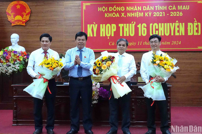 Bí thư Tỉnh ủy Cà Mau Nguyễn Tiến Hải tặng hoa chúc mừng các đồng chí vừa được bầu giữ chức Ủy viên Ủy ban nhân dân tỉnh.