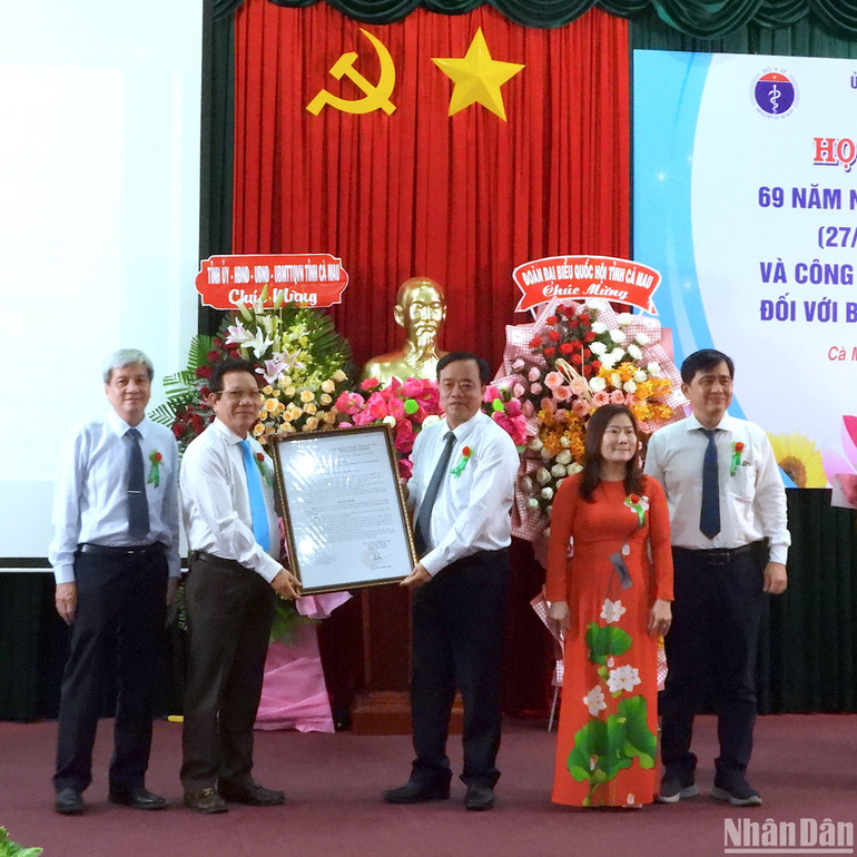 Chủ tịch Ủy ban nhân dân tỉnh Cà Mau Huỳnh Quốc Việt (giữa) trao quyết định nâng lên hạng I đối với Bệnh viện Đa khoa Cà Mau.