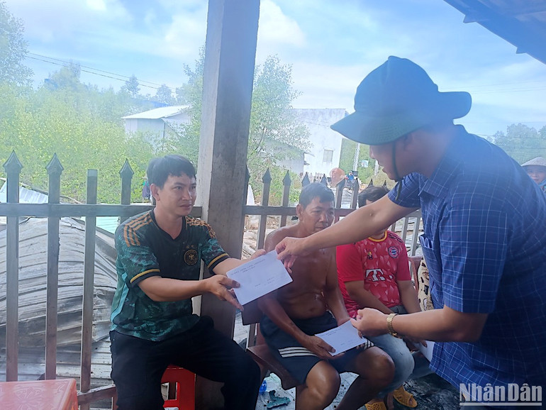 Phó chủ tịch Ủy ban Mặt trận Tổ quốc Việt Nam tỉnh Cà Mau Nguyễn Văn Khởi (bìa phải) trao hỗ trợ bước đầu của tỉnh cho các hộ gia đình bị ảnh hưởng bởi vụ cháy.