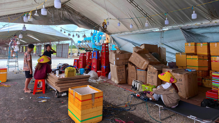 Tiểu thương mệt mỏi chờ sắp xếp hàng hóa vào khu vực trưng bày sản phẩm trong hội chợ. (Ảnh chụp chiều 8/3)