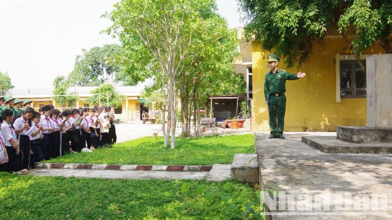 Các em học sinh tham quan và nghe giới thiệu về lịch sử, ý nghĩa của cột mốc biên giới.