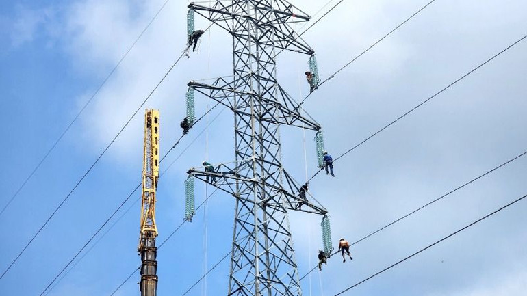 Các kỹ sư, công nhân đang tiến hành tháo dỡ trụ điện.