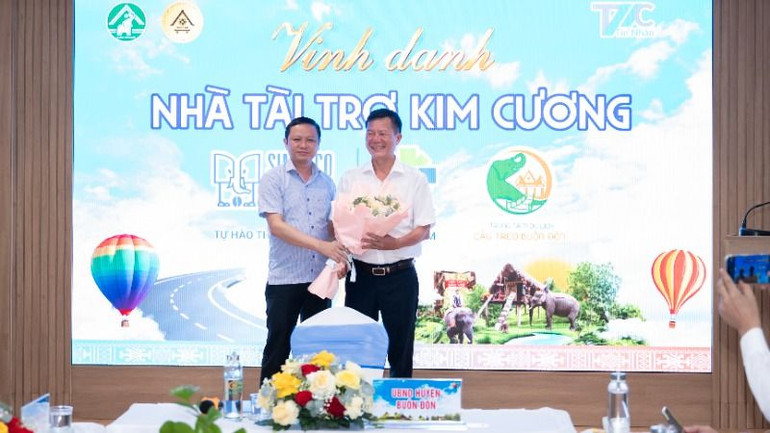 Chủ tịch Ủy ban nhân dân huyện Buôn Đôn Phạm Trung Nghĩa tặng hoa cảm ơn nhà tài trợ kim cương Ngày hội Khinh khí cầu Đắk Lắk 2025 - Bay trên đại ngàn cho đại diện Công ty trách nhiệm hữu hạn một thành viên xuất nhập khẩu 2/9 Đắk Lắk.