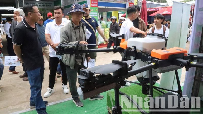 Người dân tìm hiểu hệ thống máy móc và công nghệ phun thuốc bảo vệ thực vật tự động tại Hợp tác xã Ea Tân, huyện Krông Năng, tỉnh Đắk Lắk.