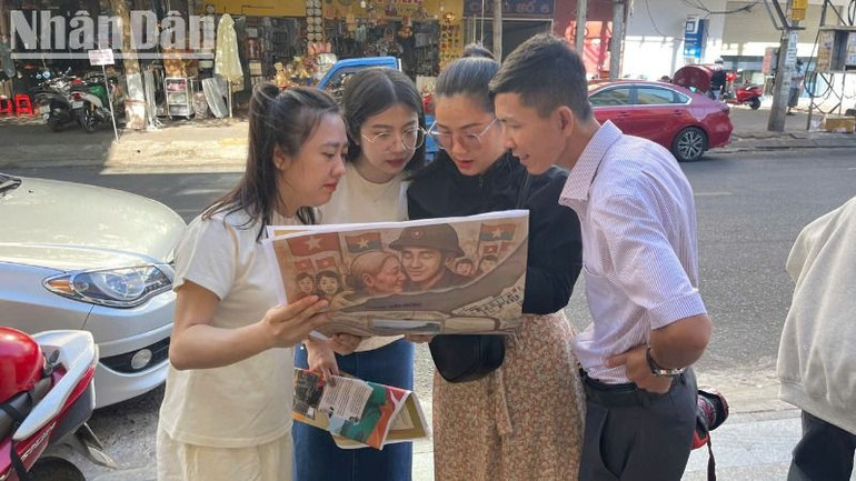 Bạn đọc trẻ hào hứng với phụ san đặc biệt của Báo Nhân Dân kỷ niệm 50 năm Ngày giải phóng miền nam, thống nhất đất nước.