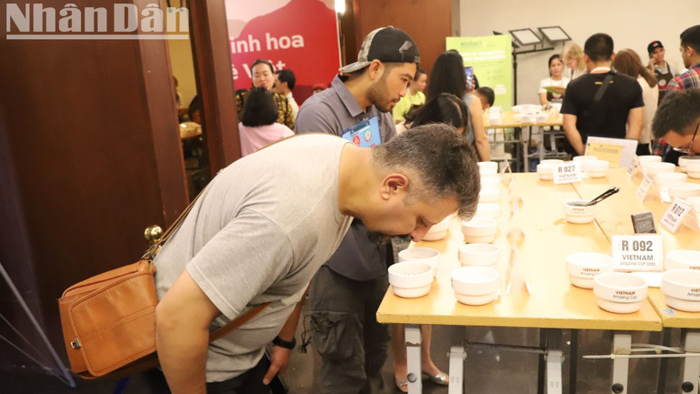 Một du khách nước ngoài trải nghiệm và thưởng thức cà-phê đặc sản.