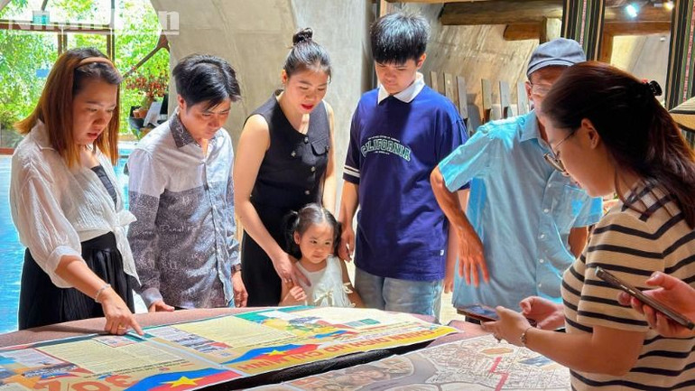 Du khách đến thăm quan Bảo tàng cà-phê thế giới trải nghiệm với phụ san đặc biệt của Báo Nhân Dân kỷ niệm 50 năm Ngày giải phóng miền nam, thống nhất đất nước.