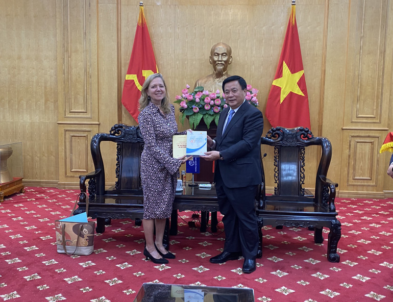 Đồng chí Nguyễn Xuân Thắng trao sách của Việt Nam tặng bà Mariam Sherman.