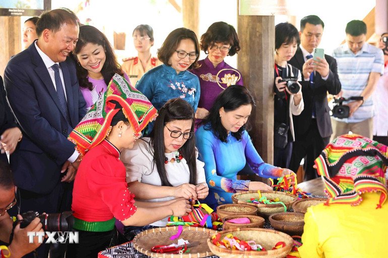 Bà Lê Thị Bích Trân, Phu nhân Thủ tướng Phạm Minh Chính trải nghiệm làm quả Còn tại làng dân tộc Thái. (Ảnh: MINH ĐỨC/TTXVN).