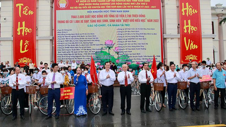 Lãnh đạo tỉnh Nam Định và đại diện Quỹ Khuyến học, khuyến tài tỉnh trao học bổng bằng xe đạp cho các em học sinh nghèo hiếu học.