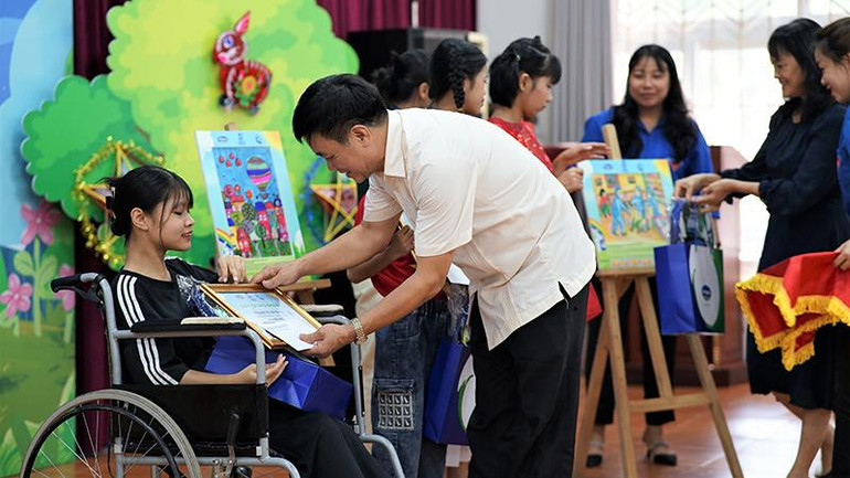 Em Nguyễn Thị Vân Giang - giải Nhì cuộc thi vẽ tranh nhận bằng khen và quà tặng khích lệ từ Giám đốc Quỹ bảo trợ trẻ em Việt Nam.