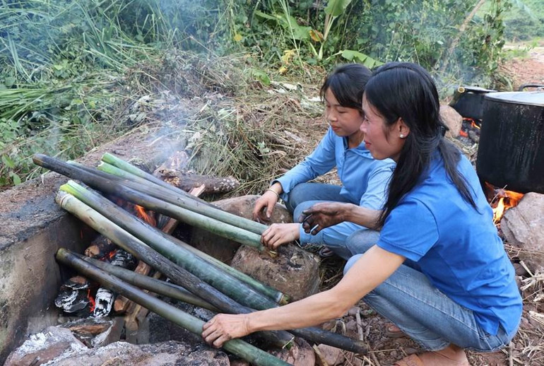 Nướng cơm lam tại bản du lịch cộng đồng Nà Sự. (Ảnh: Xuân Tiến/TTXVN)